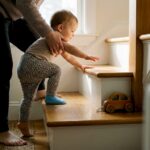 Parent guiding toddler on lower stairs