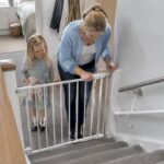 Parent checking stair gate beside KiddieRail